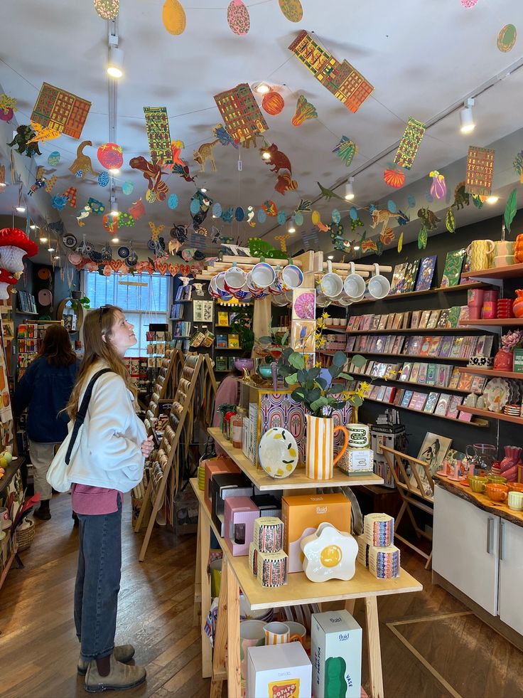 Reference shop with hanging paper sculptures, wooden tables, and dark walls